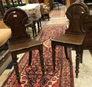 A pair of Victorian mahogany panel seated hall chairs