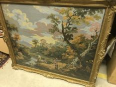 A modern needlework panel depicting a Continental scene with figures next to a stream,