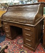 An early 20th Century oak tambour top desk with fitted interior over a single central drawer