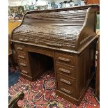 An early 20th Century oak tambour top desk with fitted interior over a single central drawer