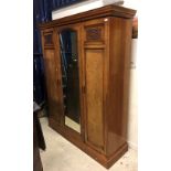 A circa 1900 ash and walnut triple wardrobe with central mirrored door enclosing linen shelves and