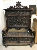 A carved painted and gilded walnut settle in the 17th Century Spanish taste the back with shield