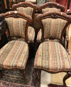 A set of four Victorian mahogany framed dining chairs with upholstered back and seat