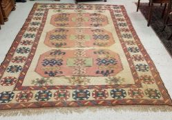 A Caucasian rug, the central panel set with three lozenge shaped medallions on a cream ground,