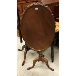 A 19th Century mahogany tea table the circular dished oval top with carved edge raised on a turned