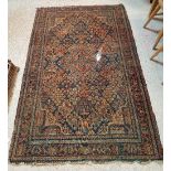 A Caucasian rug, the central panel set with floral decoration on a dark blue ground,