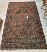 A Caucasian rug, the central panel set with floral decoration on a dark blue ground,