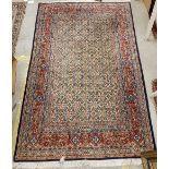 A Persian rug, the central panel set with all-over floral decoration on a cream ground,