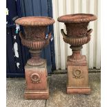 A pair of large terracotta urns on terracotta plinths CONDITION REPORTS One urn has