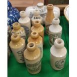 A collection of ten stoneware ginger beer bottles including "Cheltenham Spa Mineral Water Company",