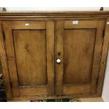 A late Victorian pine two door hanging cupboard