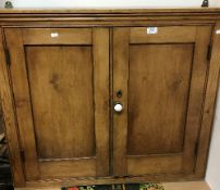 A late Victorian pine two door hanging cupboard