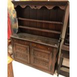 An 18th Century oak dresser (probably Northern European) the two tier boarded plate rack over two