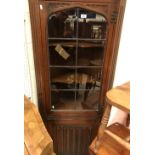 A mid 20th Century carved oak and leaded glazed free-standing corner cupboard, two slat back chairs,