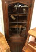 A mid 20th Century carved oak and leaded glazed free-standing corner cupboard, two slat back chairs,