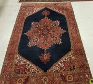 A Persian carpet with centre medallion on a blue ground within a red ground border,