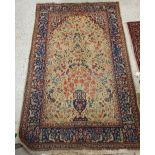 A Persian rug, the central panel set with vase and foliate and bird decoration on a gold ground,