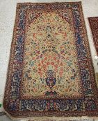 A Persian rug, the central panel set with vase and foliate and bird decoration on a gold ground,