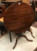 A late George III fruitwood tea table the circular snap top on a turned pedestal to cabriole