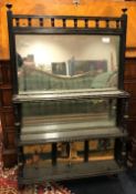 A late Victorian ebonised and gilt decorated over mantle mirror the base set with three painted