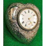 An Edwardian silver mounted dressing table clock of love heart form with embossed decoration,