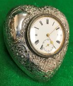 An Edwardian silver mounted dressing table clock of love heart form with embossed decoration,