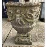 A pair of large stone urns with grape decoration