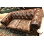 A modern brown leather buttoned Chesterfield sofa in the Victorian style,