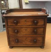 A Victorian mahogany miniature dressing chest of three long drawers