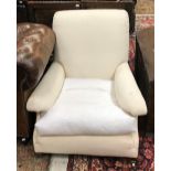 A Howard & Sons upholstered armchair on square tapered legs to brass caps and castors,