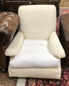 A Howard & Sons upholstered armchair on square tapered legs to brass caps and castors,