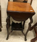 An Edwardian mahogany tea table with four shaped drop leaves on cabirole legs united by an under