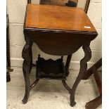 An Edwardian mahogany tea table with four shaped drop leaves on cabirole legs united by an under