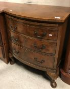 A mid 20th Century bow fronted burr walnut chest with brushing slide over three drawers on cabriole