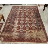A Bokhara style rug, the central panel set with repeating medallions on a red ground,