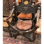 A 19th Century walnut X framed elbow chair with Bacchus mask and grape and vine decorated back rail,