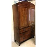 A 19th Century mahogany linen press with domed cornice over two cupboard doors enclosing a hanging