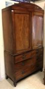 A 19th Century mahogany linen press with domed cornice over two cupboard doors enclosing a hanging