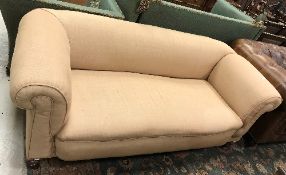 A circa 1900 upholstered Chesterfield drop arm sofa on turned legs to castors