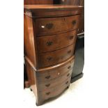 A mid 20th Century burr walnut and cross-banded bow fronted chest of three drawers over a brushing