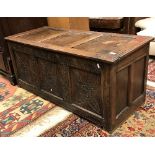 A circa 1700 oak coffer the plain three panel top over a foliate lunette carved frieze and foliate