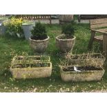 A collection of four concrete troughs together with two concrete urns