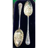 A pair of Edwardian silver berry spoons with decorative medallion ends (by William Hutton & Sons,