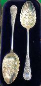 A pair of Edwardian silver berry spoons with decorative medallion ends (by William Hutton & Sons,