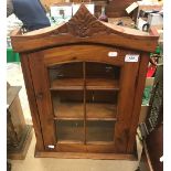 A modern hardwood wall cabinet with single glazed door,