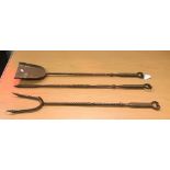 A set of three steel fire tools in the Arts and Crafts manner comprising shovel, poker and fork,