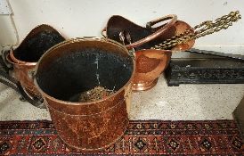 Two copper coal helmets and a copper log bucket together with three brass fire tools and a pair of