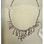 A white metal necklace set with small re