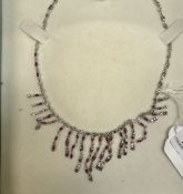 A white metal necklace set with small re