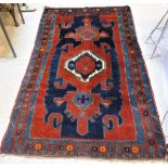 A Caucasian rug, the central panel set with central medallion on a dark red and blue ground,